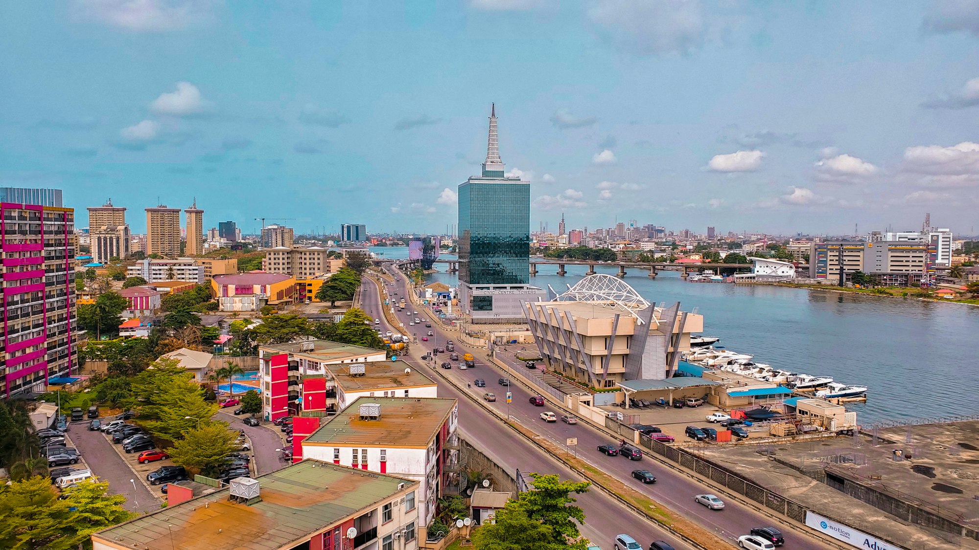 Aerial view of Lagos: the lagoon, a tall glass tower and a busy road